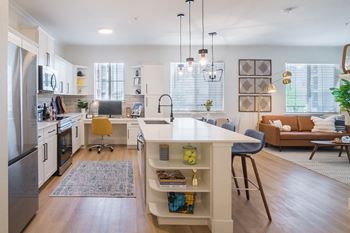 a kitchen and living room with white walls and hardwood floors at Terracina, Colorado 80020